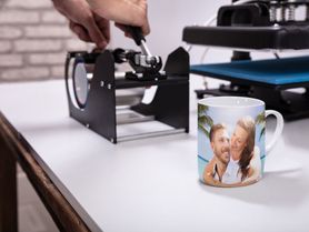 persona utilizando máquina para serigrafiar una taza